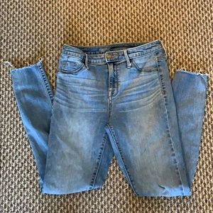 Light wash knee-ripped skinny jeans.